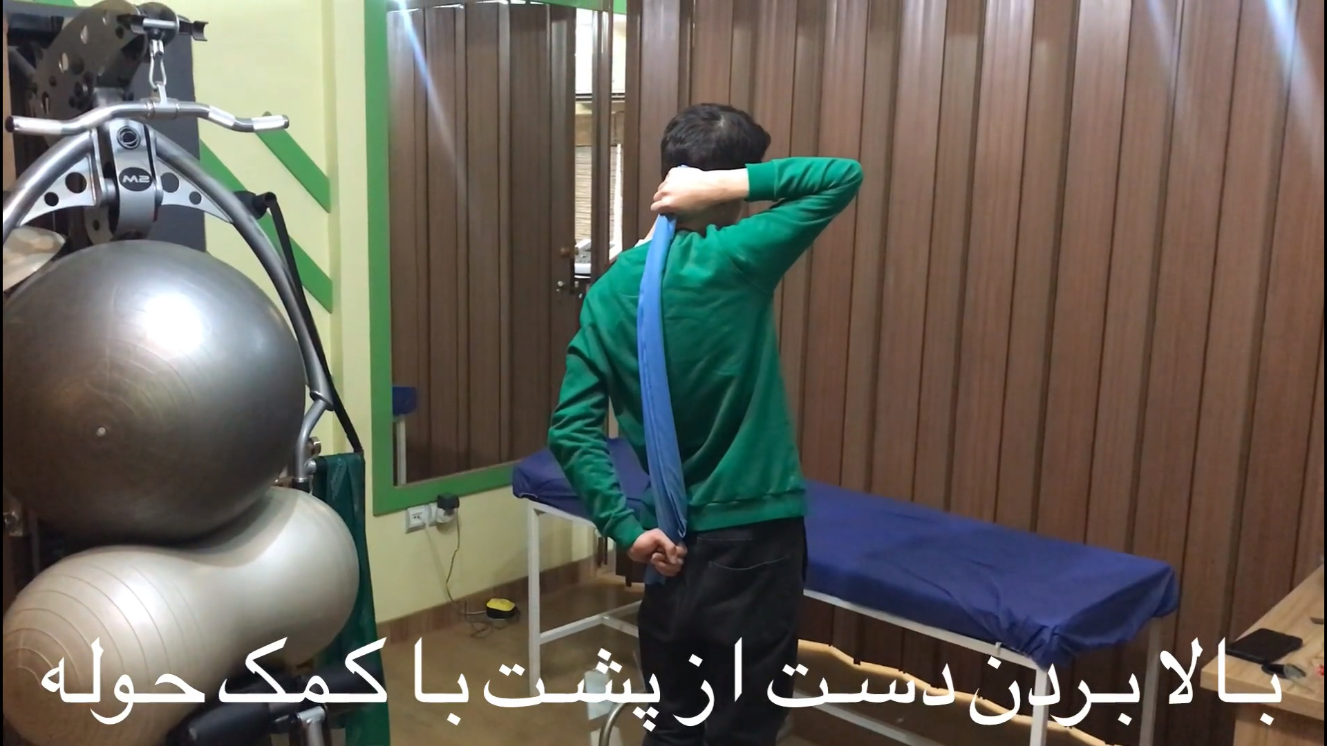 تمرین فیزیوتراپی شماره ۵۸ بالا بردن دست از پشت با کمک حوله لیزر مو
