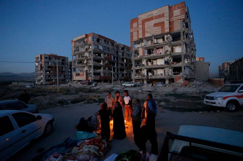 گرم شدن مردم زلزله زده سرپل ذهاب با آتش در کنار خانه های متروک و مخروب/عکس: پوریا پاکیزه؛ خبرگزاریEPA
